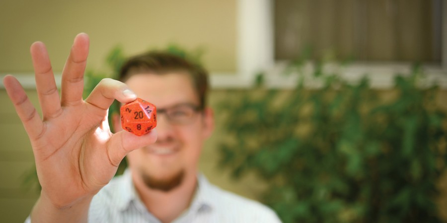 Fuller Seminary grad Joe Stroup holding an orange gaming die