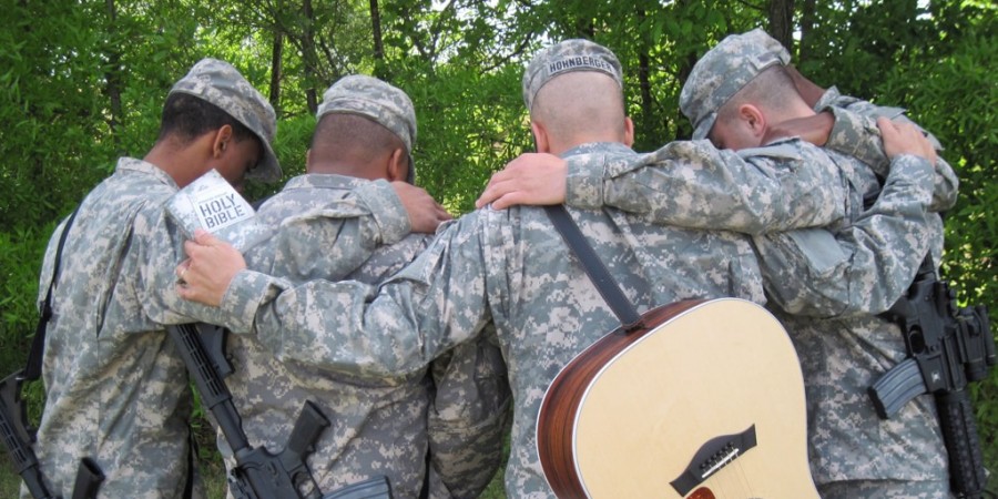 Fuller Seminary alum Jason Hohnberger praying with other soldiers